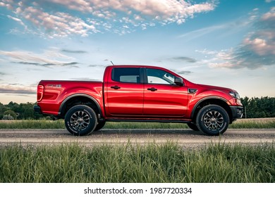 London, Canada - June 4, 2021: 2019 Ford Ranger mid-size pickup truck on gravel road, Side View, Colour: Hot Pepper.