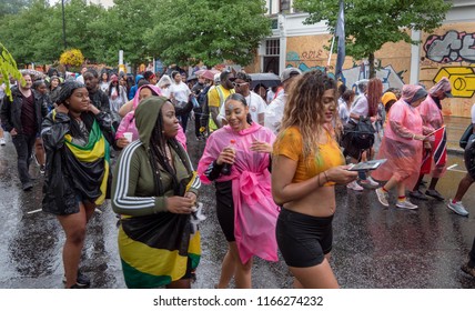 London, London City / United Kingdom - August 26, 2018: Notting Hill Carnival 2018. Carribean People Are​ Dancing In The Rain. Second Largest Carnival In The World.