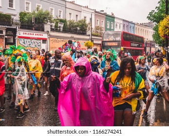 London, London City / United Kingdom - August 26, 2018: Notting Hill Carnival 2018. Carribean People Are​ Dancing In The Rain. Second Largest Carnival In The World.