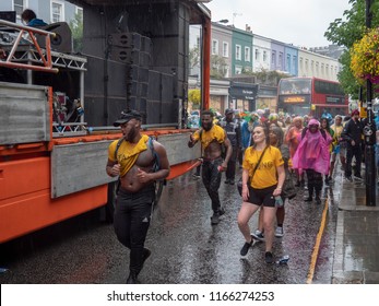 London, London City / United Kingdom - August 26, 2018: Notting Hill Carnival 2018. Carribean People Are​ Dancing In The Rain. Second Largest Carnival In The World.