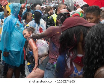 London, London City / United Kingdom - August 26, 2018: Notting Hill Carnival 2018. Carribean People Are​ Dancing In The Rain. Second Largest Carnival In The World.