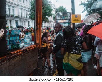 London, London City / United Kingdom - August 26, 2018: Notting Hill Carnival 2018. Carribean People Are​ Dancing In The Rain. Second Largest Carnival In The World.