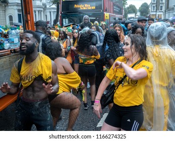 London, London City / United Kingdom - August 26, 2018: Notting Hill Carnival 2018. Carribean People Are​ Dancing In The Rain. Second Largest Carnival In The World.