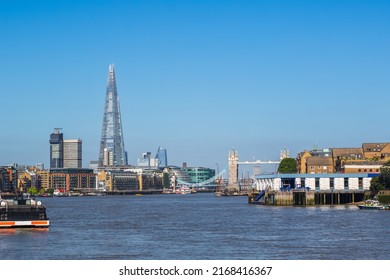 London cityscape seen from the River Thames with cloudless sky, including Guy's Hospital, The Shard, Tower Bridge and Wapping Police Boatyard
