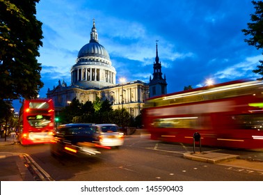 London Cityscape With St Paul's Cathedral And Moving Double Decker Buses At Night