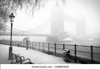 London, December 18th, 2010: B&W Tower Bridge In Huge Snow Storm With Tourist Taking Picture Under Umbrella