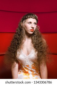 London, England, 05/0/2017 A Glamorous Woman With Platted Hair Braids And Platted Fringe Posing And Modelling For The Camera In A Pink And Red Leather Booth Background. Modelling Hair Styles.