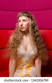 London, England, 05/0/2017 A Glamorous Woman With Platted Hair Braids And Platted Fringe Posing And Modelling For The Camera In A Pink And Red Leather Booth Background. Modelling Hair Styles.