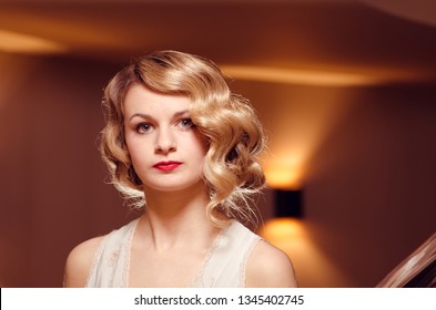 London, England, 05/05/2017, A Stylish Brunette Retro Vintage Fashionable Girl With Vintage 1920 Style Hair Style Posing In A Film Noir Warm Glowing Setting. 1920s Style Fashion Trend.