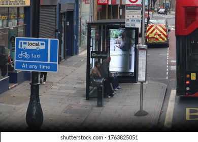 London/ London/ England - 09/09/2019: Walking On The Streets Of London. Muslin , Islamic, Arabian Woman In A Bus Shelter. Sharia Law. Arabian, Arabian Woman, Black Background, Bus, Bus Shelter Ad Day