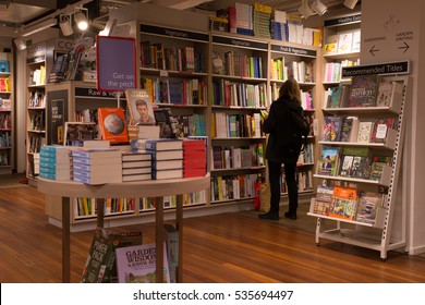 London, England - 11 December 2016: Interior Of A Modern Bookshop With Woman From Behind Browsing The Collection.