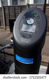 
London, England - ‎April 13 ‎2020: Close up of an electric vehicle recharging point in a residential road with an electric Taxi plugged in charging. 