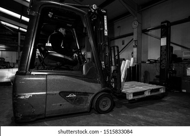 London, England, 28/01/2019 Black And White Image Of A Forklift Lifting Pallet Onto A Rotating Industrial Lazy Susan For Wrapping A Stack Of Boxes Together In Plastic Wrap. Keeping Product Safe 