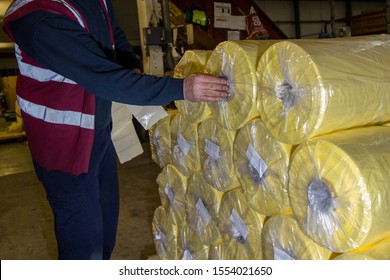 London, England, 28/01/2019 Image Of A Factory Worker Labelling Up Pallets Stacked With Yellow Plastic Wrap In Tubes With Stickers To Mark The Product And Where It Is Being Sent Or Shipped To