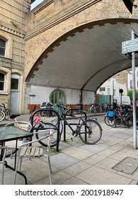 LONDON, ENGLAND - 28.06.2021. Bicycles Parked Under The Fulham Railway Bridge Along Renelagh Gardens Street. Arch Of Old Bridge. Selective Focus. Vertical