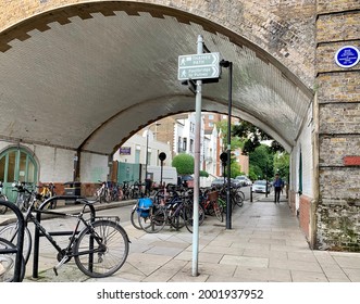 LONDON, ENGLAND - 28.06.2021. Bicycles Parked Under The Fulham Railway Bridge Along Renelagh Gardens Street. Arch Of Old Bridge. Selective Focus. Horizontal