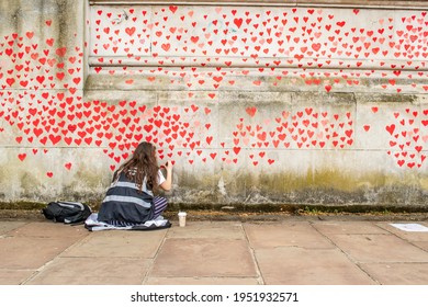 LONDON, ENGLAND- 31 March 2021: Female Volunteer Adding Lovehearts To The National Covid Memorial Wall