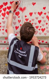 LONDON, ENGLAND- 31 March 2021: Volunteer Adding Hearts To The National Covid Memorial Wall