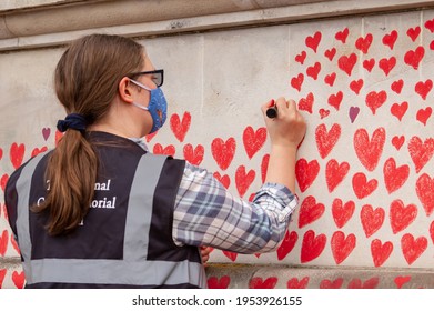 LONDON, ENGLAND- 31 March 2021: Volunteer Adding Love Hearts To The National Covid Memorial Wall