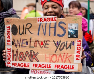 London, England. 3rd February 2018. EDITORIAL - Black Woman Holding Homemade Poster At The NHS In Crisis Demonstration Through Central London, In Protest Of Underfunding & Privatisation Of The NHS.