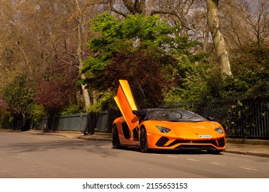London, England - April 2022: Lamborghini Aventador S Roadster in bright orange colour with scissor doors open. This is a V12 Italian supercar with 730 horsepower.