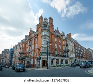 LONDON, ENGLAND - AUGUST 18, 2018: The upscale Mayfair district features a wide choice of luxury shops housed in stunning historic Victorian red brick buildings with intricate facades and balconies.