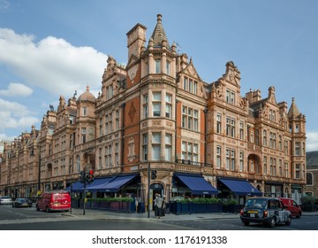 LONDON, ENGLAND - AUGUST 18, 2018: The upscale Mayfair district features a wide choice of restaurants and shops housed in the historic Victorian red brick buildings with intricate facades.