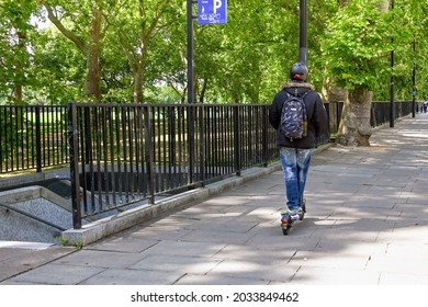 London, England - August 2021: Person Riding An Electric Scooter On A Pavement In Central London