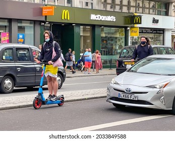 London, England - August 2021: Person Riding An Electric Scooter On A Street In Central London