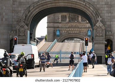 London, England - August 2022: People and traffic waiting for Tower Bridge to reopen after allowing a ship to pass on the River Thames.