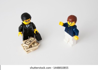 London, England - CIRCA Jul 2019:Toy Manager And Worker. Management Has All The Cash, Worker Has A Frustrated And Angry Face. Symbolic Of Salary Disparity; Banker's Bonuses; Class Divide Etc.