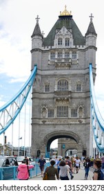 London/ England - July 07, 2016:  Isolated Frontal Full Tower Bridge Blue Railings, View On Walking Tourists On Sidewalk Above The Thames On A Sunny Day, Blue Sky White Clouds.