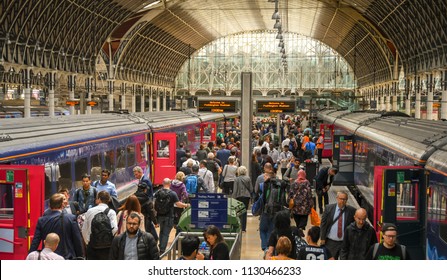 LONDON, ENGLAND - JULY 2018: Passengers walking along a platform at London Paddington Station after arriving at their destination.