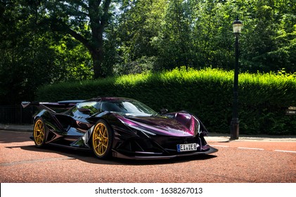 London, England - July 2018: purple Apollo Intensa Emozione prototype supercar with golden wheels driven in a park in central London, attending a large automotive gathering.