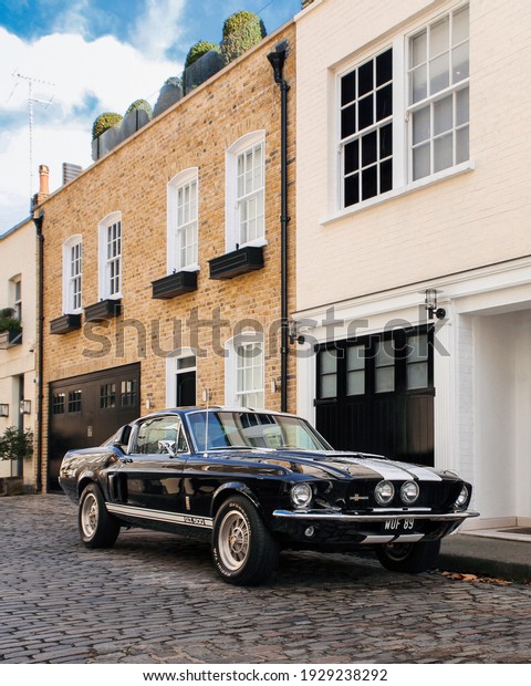 London, England - July 2020: black with white stripes\
Shelby Mustang GT500 classic muscle car parked at residential mews\
in central London. 