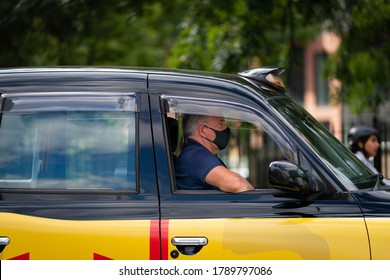 LONDON, ENGLAND - JULY 28, 2020: Traditional London Black Taxi Cab With The Driver Wearing A Face Mask During The COVID-19 Pandemic - 078