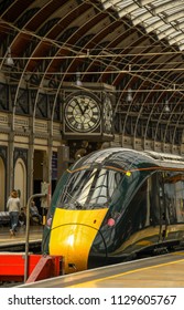 LONDON, ENGLAND - JUNE 2018: New electro diesel express train at London Paddington Station. The original station clock is in the background.