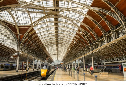 London, England - June 2018: Wide Angle View Of Platforms And The Arched Roof Of London Paddington Railway Station. A High Speed Train Is Leaving One Of The Platforms.