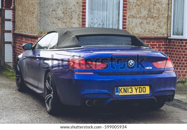 LONDON, ENGLAND - MARCH 1st, 2017: Blue BMW M6\
parked next to a house in a residential area in London, close up \
view from behind left\
side.