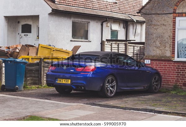 LONDON, ENGLAND -\
MARCH 1st, 2017: Blue BMW M6 parked next to a house in a\
residential area in London, back\
view.