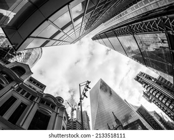 London, England, March 6th 2022: London Finance District Tall Skyscrapers. Abstract Architecture Using An Ultra Wide Angle Fish Eye Lens, Low Viewpoint  Perspective. Copy Space Centre. Black And White