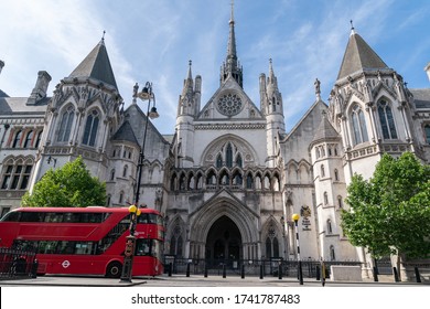 LONDON, ENGLAND - May 21, 2020: Closed Royal Courts of Justice in London due to Coronavirus COVID-19 with red London Bus passing in front