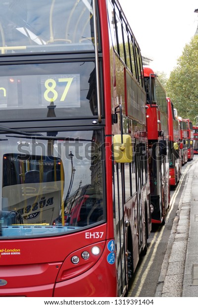 London England. May. London Transport\
buses in half  profile parked by the side of the road on double\
yellow lines. No people in frame. Number 87 on leading\
bus