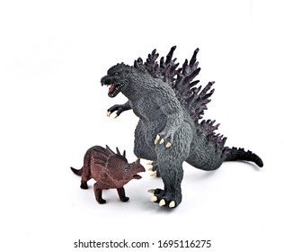 London, England. Monday 6th April 2020. This is an Illustrative Editorial photo of Two plastic models, One of Godzilla and the other a Triceratops.