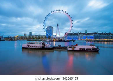 LONDON, ENGLAND - NOVEMBER, 2015, The London Eye With French Flag Colors And Two Boats At Sunrise - London's Tribute To Paris Attacks