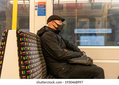 LONDON, ENGLAND - OCTOBER 23, 2020:  Businessman Wearing A Face Mask With Closed Yes During A Rush Hour Commute On The London Underground  During The COVID Coronavirus Lockdown In London, England- 203