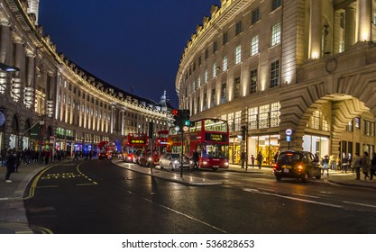 LONDON, ENGLAND - OCTOBER 28,2016: Piccadilly Circus street in London by night with red buses on the road. Panorama.