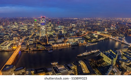 London, England - Panoramic aerial skyline of London by night. This view includes London Bridge, Tower Bridge, the Tower of London and famous business district with skyscrapers