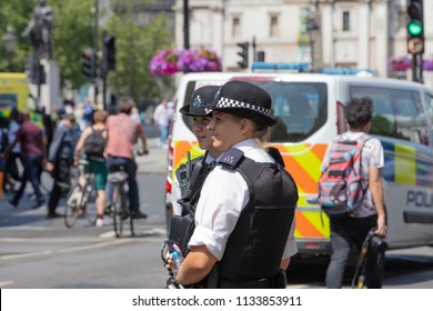 London, England, UK; 13th July 2018; Two Female Metropolitan Police Officers In The Street.  Unfocused Police Van Behind