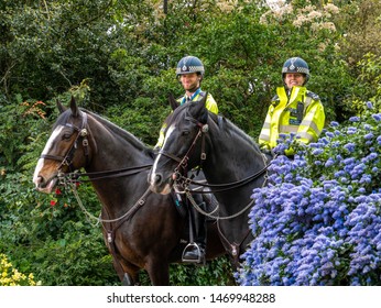 London, England, UK - April 28, 2019: Happy Metropolitan Police Officers On Horses Outdoors In A Park In Westminster Area